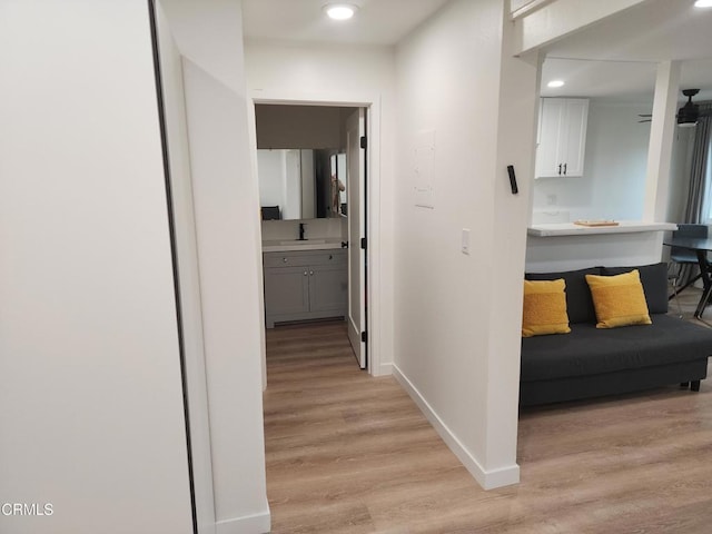 hallway with sink and light wood-type flooring