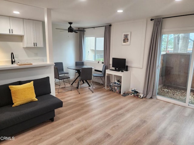 living room with ceiling fan, a healthy amount of sunlight, and light hardwood / wood-style flooring