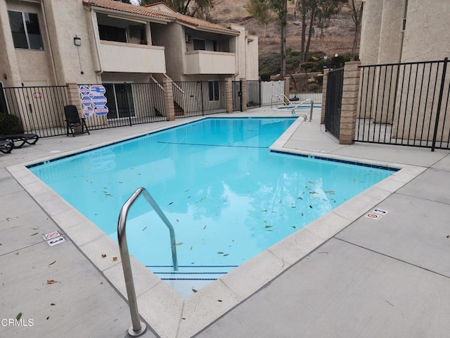 community pool featuring a patio area and fence