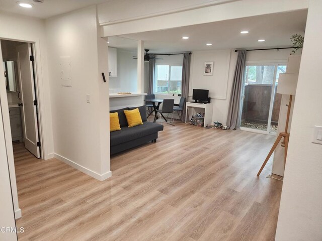 living area with baseboards, light wood-type flooring, a ceiling fan, and recessed lighting