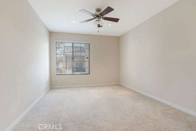 unfurnished room with light colored carpet and ceiling fan