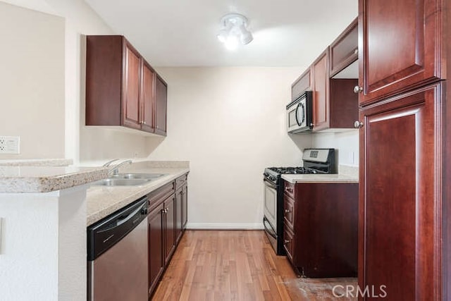 kitchen featuring stainless steel appliances, sink, and light hardwood / wood-style flooring