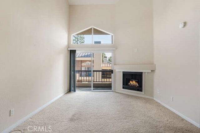 unfurnished living room featuring a high ceiling and carpet floors