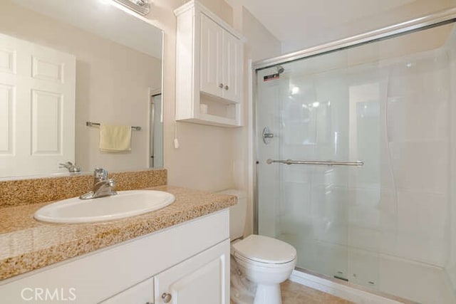 bathroom with vanity, an enclosed shower, and toilet