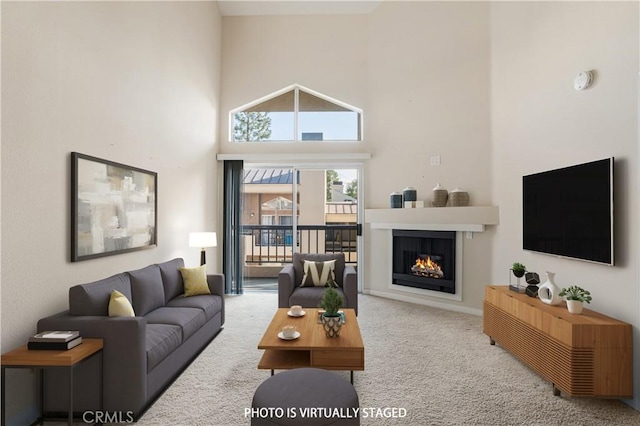 carpeted living room featuring a towering ceiling