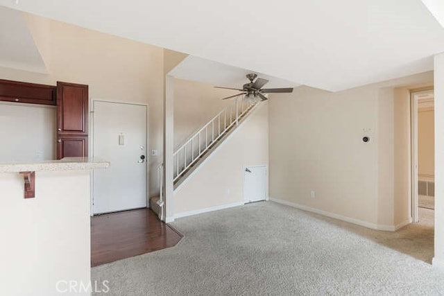 unfurnished living room featuring light carpet and ceiling fan