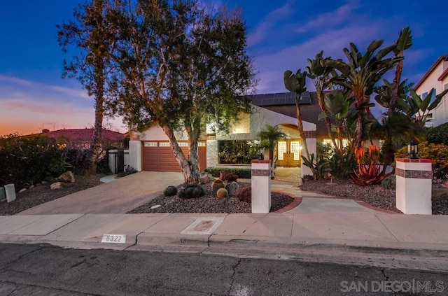 view of front of home featuring a garage and solar panels