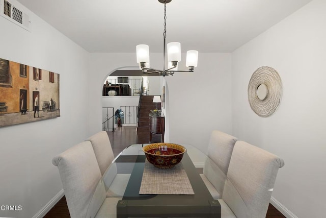 dining area with dark hardwood / wood-style floors and a chandelier