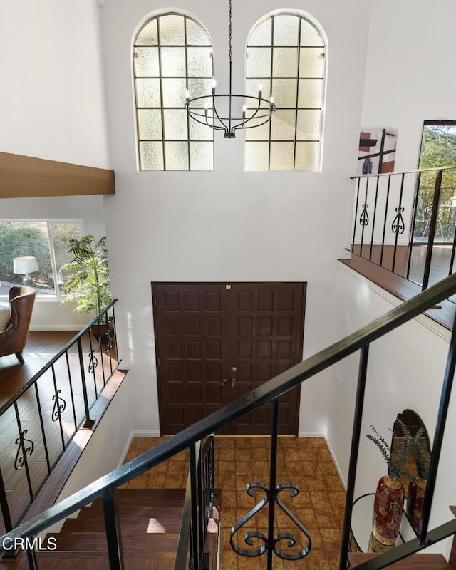 staircase with a towering ceiling and a chandelier