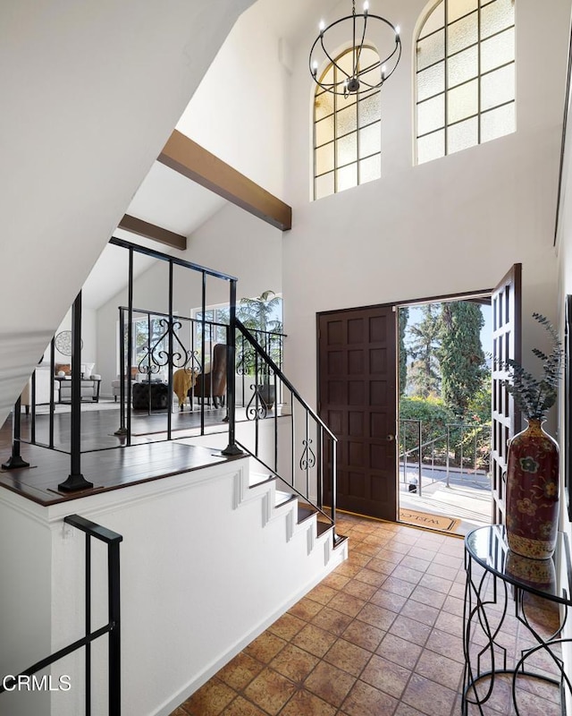 foyer entrance featuring a towering ceiling and a notable chandelier