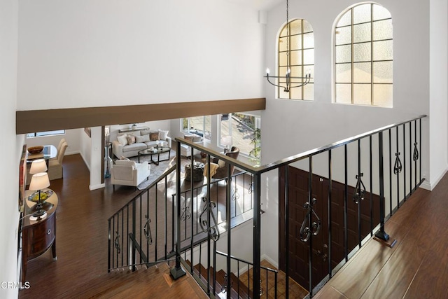 stairs featuring an inviting chandelier and wood-type flooring