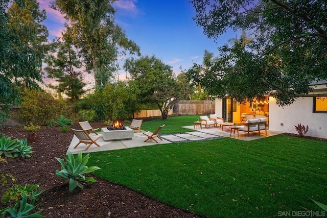 yard at dusk featuring a patio area and an outdoor living space with a fire pit