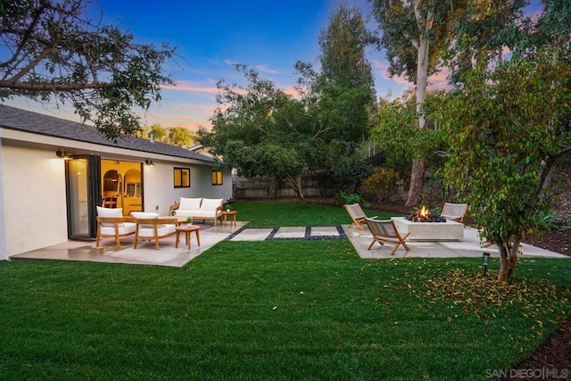 yard at dusk with an outdoor living space with a fire pit and a patio area