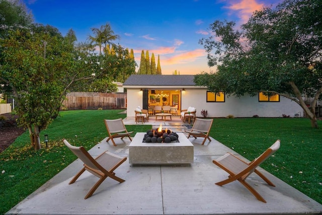 patio terrace at dusk with an outdoor living space with a fire pit and a lawn