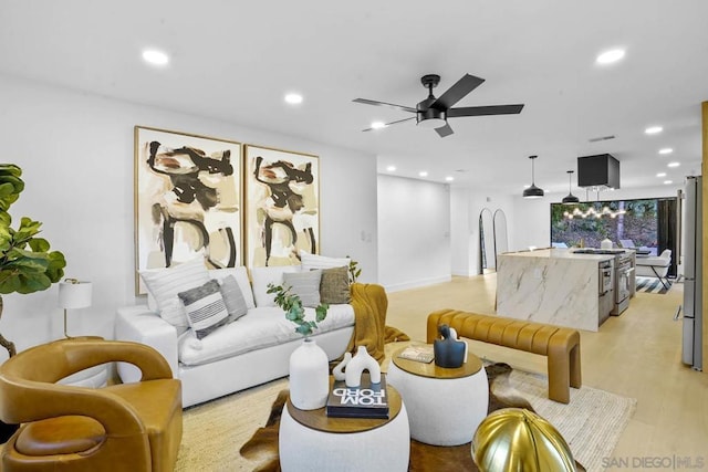 living room featuring ceiling fan and light hardwood / wood-style flooring