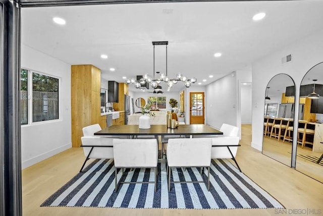 dining room with an inviting chandelier and light hardwood / wood-style floors