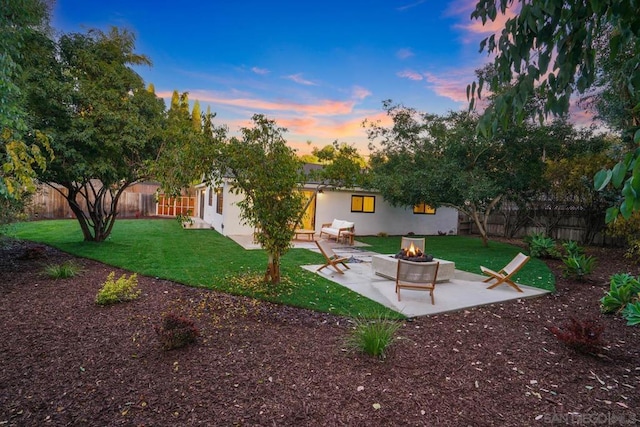 yard at dusk with a patio area and an outdoor fire pit