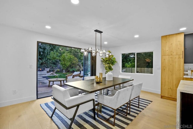 dining area with a notable chandelier and light hardwood / wood-style floors