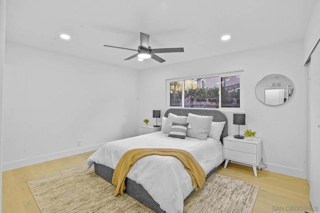 bedroom with wood-type flooring, ceiling fan, and a closet