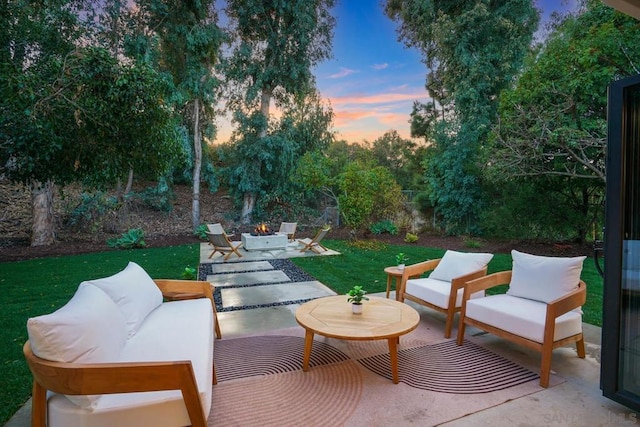 patio terrace at dusk featuring a lawn and outdoor lounge area