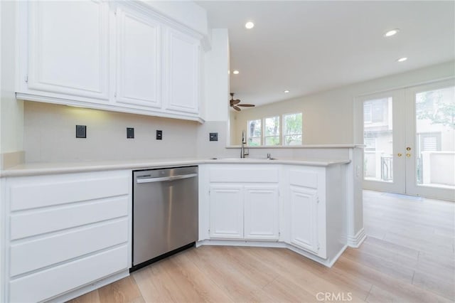 kitchen with white cabinetry, sink, stainless steel dishwasher, and kitchen peninsula