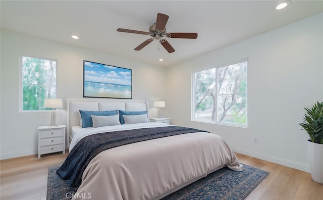 bedroom featuring multiple windows, ceiling fan, and light wood-type flooring