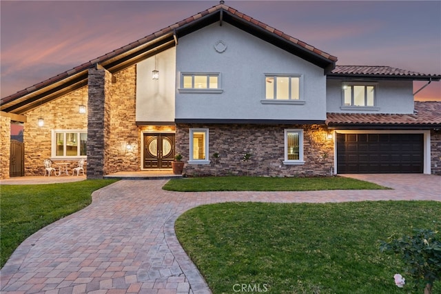 view of front of property with a garage and a lawn