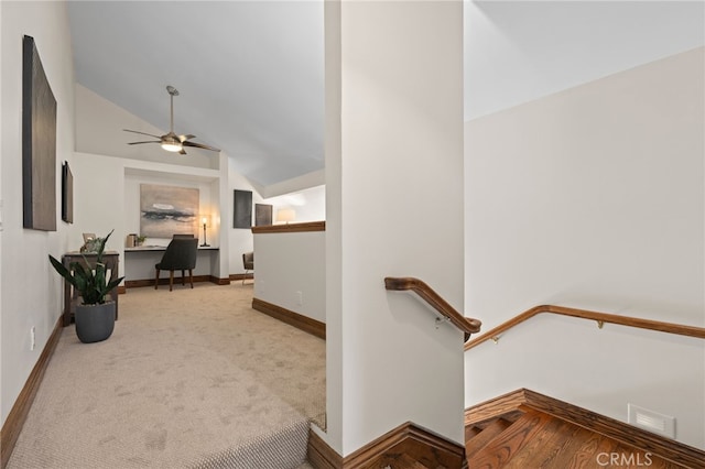 hallway featuring lofted ceiling and light colored carpet