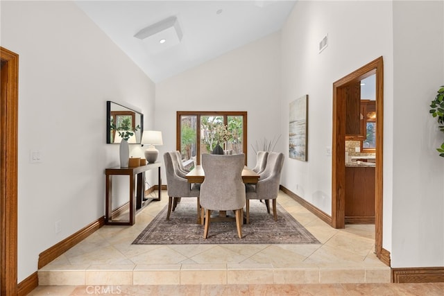 dining room featuring light tile patterned floors and high vaulted ceiling