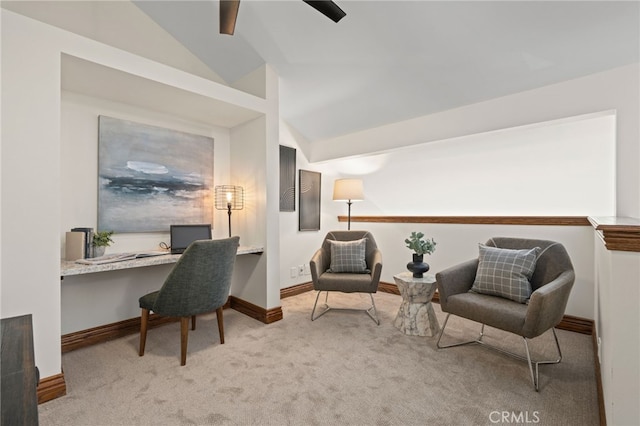 sitting room featuring built in desk, light colored carpet, and vaulted ceiling