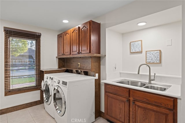 clothes washing area featuring cabinets, light tile patterned flooring, sink, and washer and clothes dryer