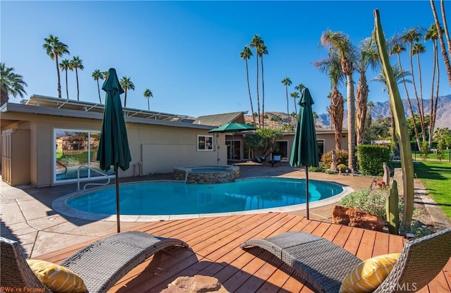 view of swimming pool with a wooden deck and an in ground hot tub