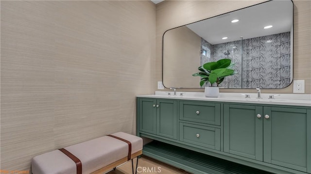 bathroom with double vanity, tile walls, walk in shower, and a sink