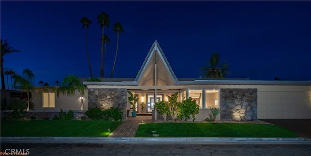 view of front of house with a garage and a yard