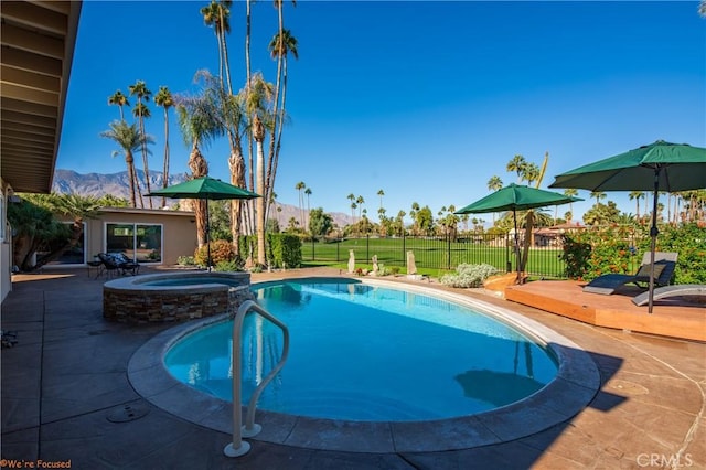 view of pool featuring a mountain view, a patio area, and an in ground hot tub