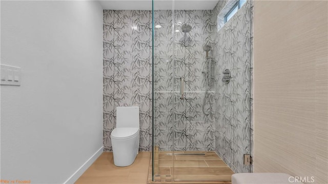 bathroom featuring walk in shower and toilet