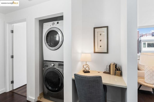 laundry room with dark hardwood / wood-style floors and stacked washer and clothes dryer