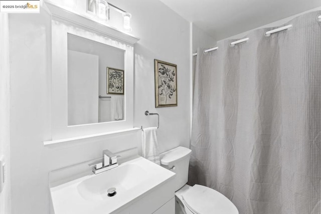 bathroom with vanity, toilet, and curtained shower