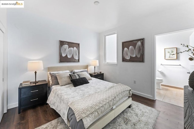 bedroom featuring dark hardwood / wood-style floors and ensuite bath