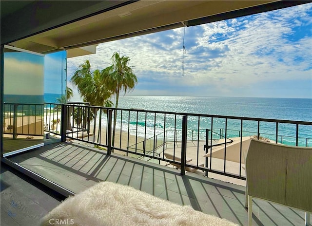 balcony with a beach view and a water view