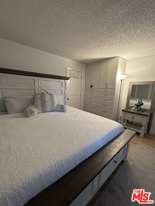 bedroom with hardwood / wood-style flooring and a textured ceiling