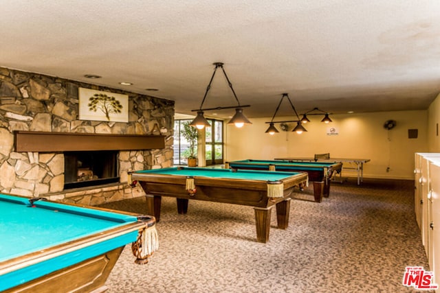 playroom featuring a stone fireplace, carpet floors, a textured ceiling, and billiards