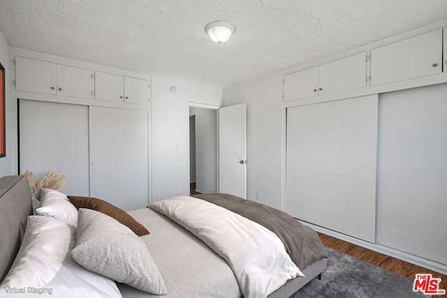 bedroom featuring dark wood-type flooring and a textured ceiling