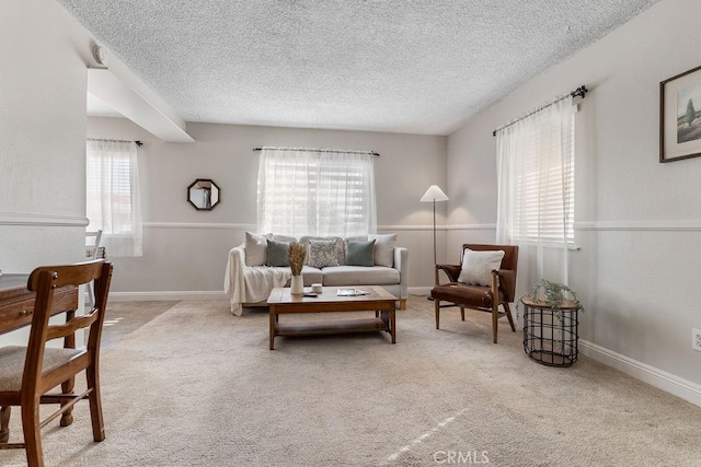 living room with plenty of natural light, light carpet, and a textured ceiling