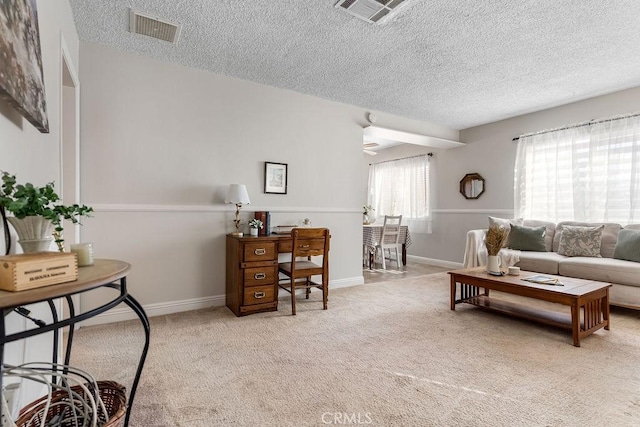 living room featuring light carpet and a textured ceiling