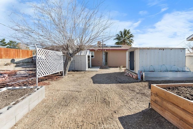 rear view of property featuring a storage shed