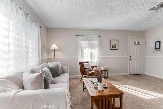 living room with light carpet and a textured ceiling