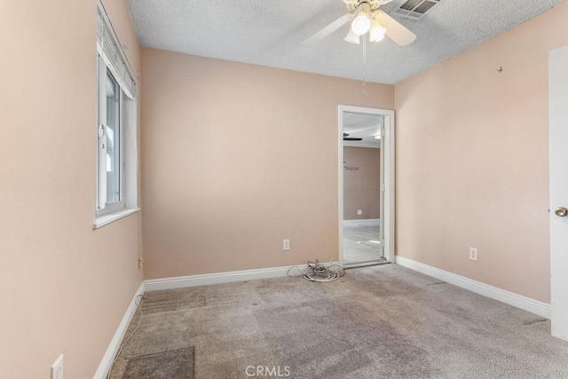 unfurnished room with ceiling fan, light colored carpet, and a textured ceiling