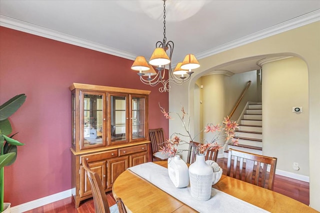 dining space featuring crown molding, wood-type flooring, and an inviting chandelier