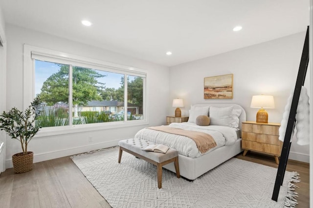 bedroom featuring multiple windows and light hardwood / wood-style floors